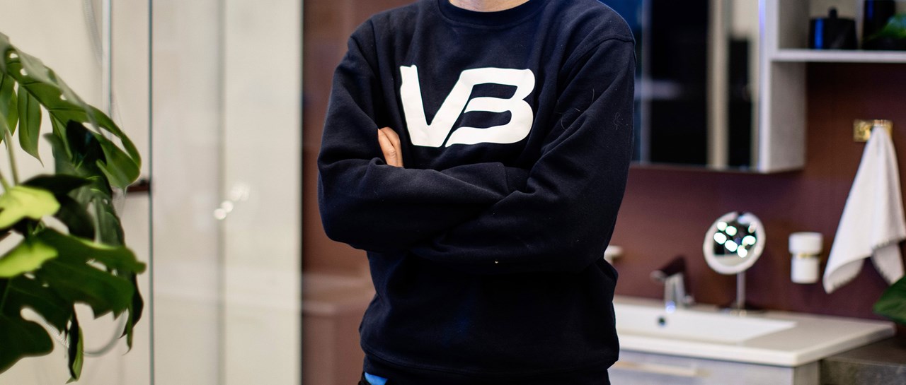 VB Rørlegger med mørkeblå genser og hvit VB logo på brystet